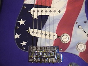 M. Rock's Fender Strat, a blue guitar
  with an American flag pick guard